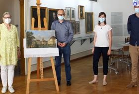 Übergabe des Gemäldes im Patrizierzimmer des Stadtmuseums: Das Gemälde ist auf einer Staffelei ausgestellt, daneben stehen vier Personen.