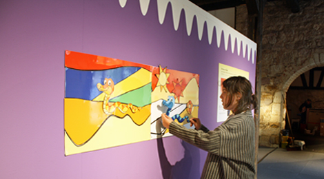 Eine Besucherin stellt aus mehreren flachen Elementen ein Bild zusammen.