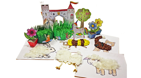 Eine Zusammenstellung von vielen Bastelarbeiten aus Papier und Kartonmodellbogen. Zum Beispiel Osternester, Blumentöpfe, ein bemalter Baum aus Papier, zwei Schafe mit Körpern aus Wolle und Beinen aus Schnüren, ein Bild von einem gemalten Schaf, dessen Körper aus Wolle gebildet ist.