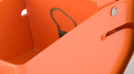 Detailfoto: Knapper Einblick in eine viereckige Vertiefung, am Rand ein Schlitz als Führung und eine Schraube. Alles sieht nach orangefarbenem Kunststoff aus.